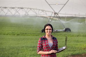 farmer in field inspecting the irrigation system